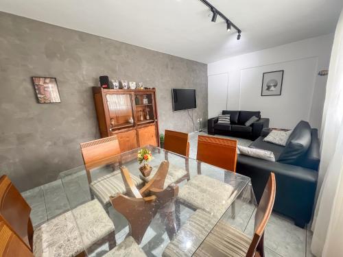 a living room with a glass table and a couch at Apartamento VIP Centro Serra Negra - Familiar in Serra Negra