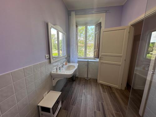 a bathroom with a sink and a mirror and a window at Paradiso verde in Lucca