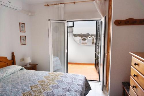 sypialnia z łóżkiem i przesuwanymi drzwiami szklanymi w obiekcie Casa la Buganvilla-Mojácar Playa w mieście Mojácar