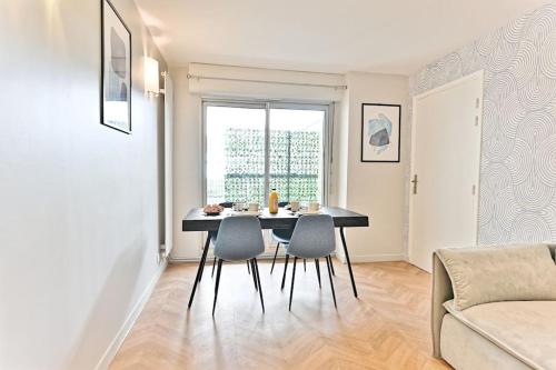 un salon avec une table et des chaises de salle à manger dans l'établissement Appartement spacieux et paisible Paris 19ème, à Paris