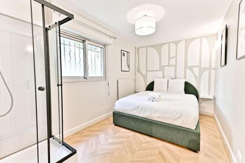 une chambre avec un lit et une douche en verre dans l'établissement Appartement spacieux et paisible Paris 19ème, à Paris