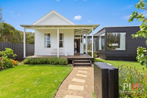 a white house with a porch and a yard at Charming 4 BR Cottage Retreat in Newhaven