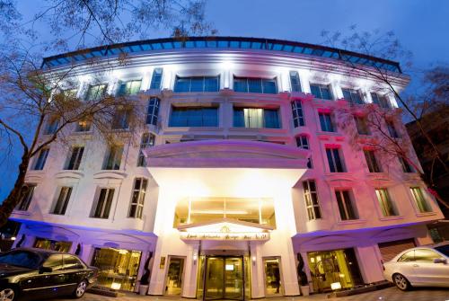 un bâtiment éclairé avec des voitures garées devant lui dans l'établissement Limak Ambassadore Hotel Ankara, à Ankara