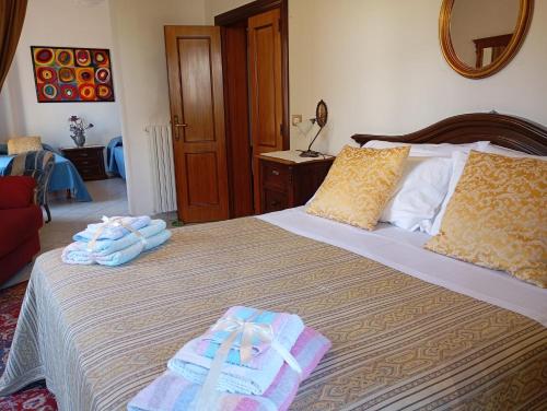 a bedroom with a bed with towels on it at MARIA HOLIDAY HOMES La Pineta di Sinalunga in Sinalunga