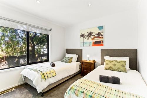 two beds in a room with a window at King Bed' tranquil paradise Cowes 4BR 4BTH in Cowes