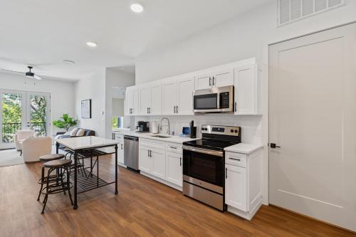 a kitchen with white cabinets and a table and a microwave at The Corbin 1101 - Magnolia Haven in Fort Worth