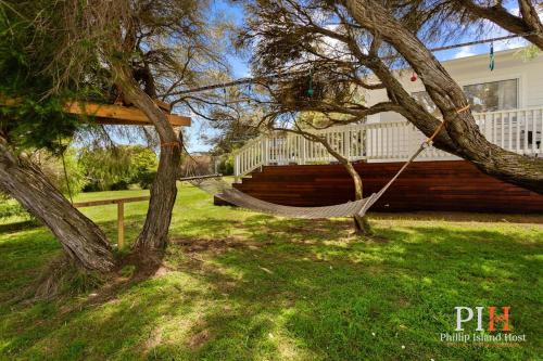 a hammock hanging from a tree in a yard at Smith Beach Family House Sleep 6 in Smiths Beach