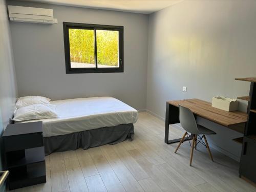 une chambre avec un lit, un bureau et une fenêtre dans l'établissement Location Maison contemporaine, piscine, 6-8 couchages, à Six-Fours-les-Plages