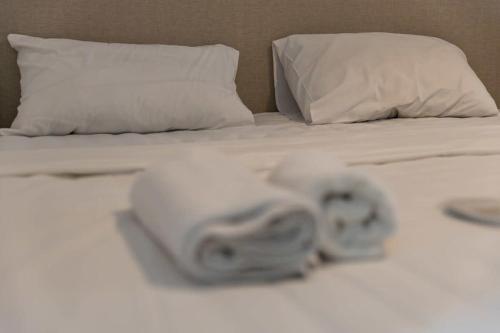 dos rollos de toallas en una cama en Cozy Studio Apartment For 3 with a pool, en Batumi