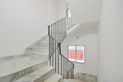 a staircase with a window in a white wall at Hotel O Royal Palace in Kolkata