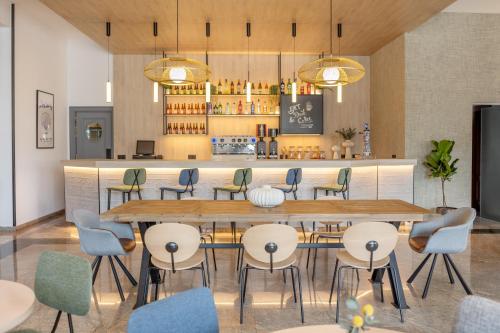 a restaurant with a large wooden table and chairs at Hotel Santiago Plaza Affiliated by Meliá in Santiago de Compostela