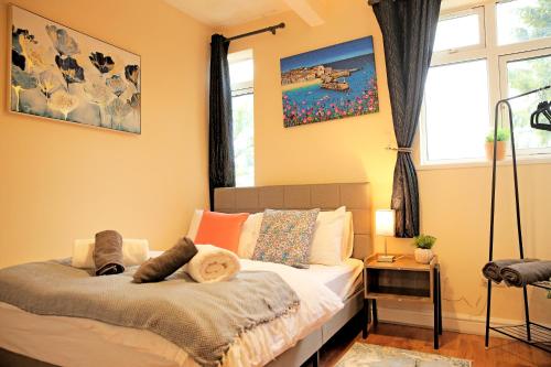 a bedroom with a bed and a window at Ensuite Near Luton Station in Luton