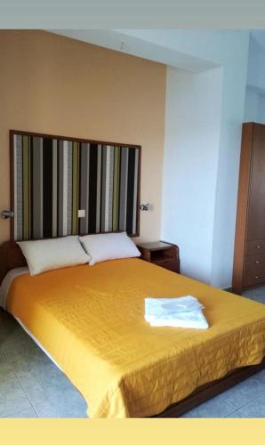 a bedroom with a large bed with a yellow blanket at Studio Poseidon in Lipsoi