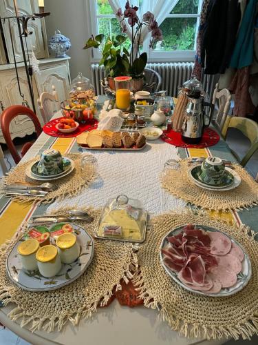 a table with plates of food on top of it at "Aux Chants des Oiseaux" Domaine de la Renardière in Les Grandes-Loges