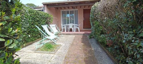 a patio with chairs and a table in front of a house at Maison à 800m de la plage classée 1 étoile in Capbreton