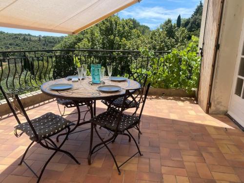 une table et des chaises sur un balcon avec vue dans l'établissement Villa entière à 550 m du centre-ville, à Valensole