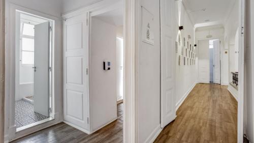 a hallway with white walls and wood floors at Hostel Casa d'Alagoa in Faro