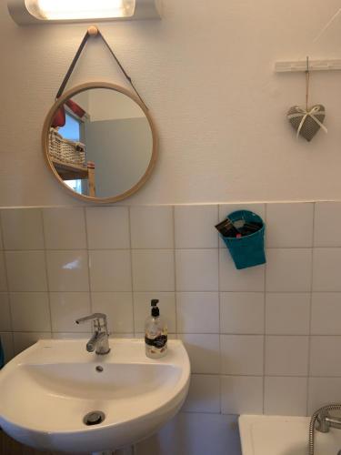 une salle de bain avec un lavabo et un miroir dans l'établissement Escale beaunoise, à Beaune