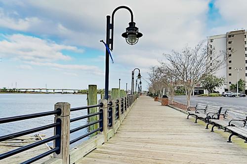 a boardwalk with benches and a street light next to the water at River View Condo 602 & 603 in Wilmington
