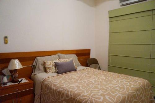 a bedroom with a bed and a dresser with a lamp at Beautiful house in secure subdivision in Acapulco