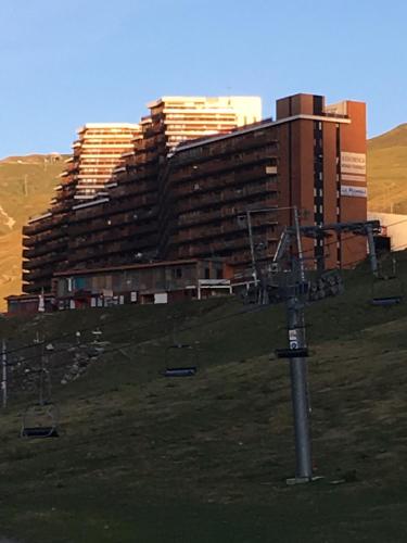 un grand bâtiment sur une colline avec une remontée mécanique dans l'établissement La Mongie Tourmalet, à Bagnères-de-Bigorre