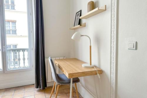 un bureau avec une lampe et une chaise à côté d'une fenêtre dans l'établissement Flexliving - room - Echiquier, à Paris