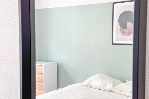 - une chambre avec un miroir à côté d'un lit dans l'établissement Flexliving - room - Echiquier, à Paris