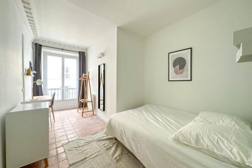 a white bedroom with a bed and a window at Flexliving - room - Echiquier in Paris
