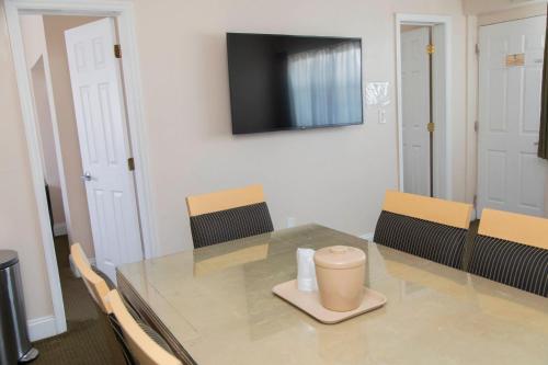 a dining room with a glass table and a television at Beach Place Hotel in Miami Beach