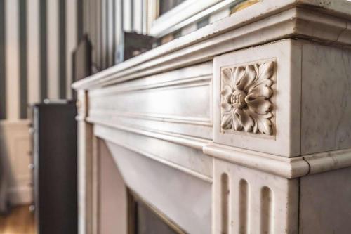 un pilier de pierre avec une sculpture sur le côté d'un bâtiment dans l'établissement Le Rendez-Vous des Promenades #Gare-Cathédrale, à Reims