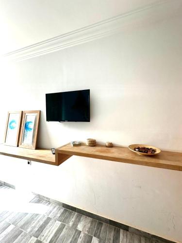 a living room with a television on a wall at Imsouane surf house in Imsouane