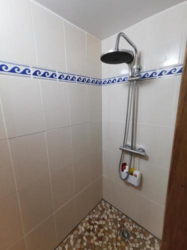 une salle de bain avec douche carrelée de blanc dans l'établissement Petite maison agréable à 300 m de la plage, à Dolus-d'Oléron