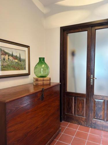 a room with a glass vase sitting on a wooden cabinet at casa di Gigia in Serra San Bruno