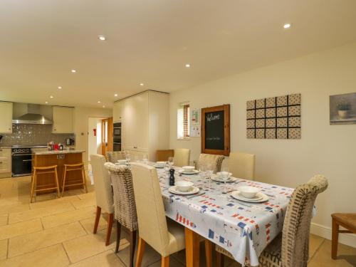 a kitchen and dining room with a table and chairs at Lower Farm Barn in Oxford