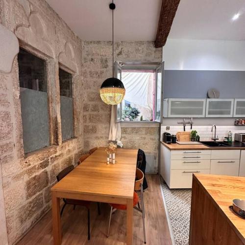 - une cuisine avec une table en bois dans une chambre dans l'établissement Chic Renovation of Medieval Monastery, à Montpellier