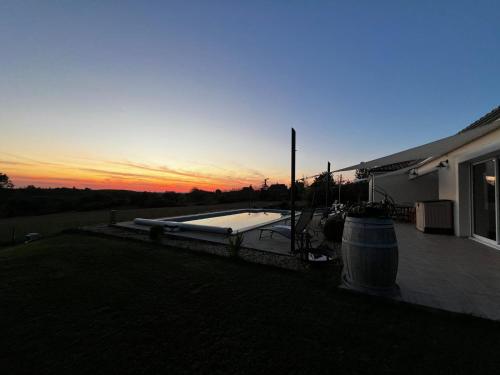 une cour avec une piscine au coucher du soleil dans l'établissement Villa coucher de soleil, à Pontours