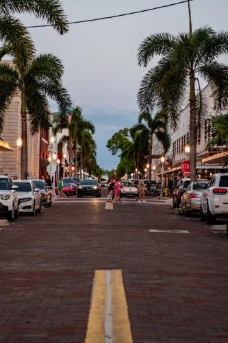 a city street with palm trees and cars parked at Walk to Best Eats and Shops and Stay in Style in Fort Myers