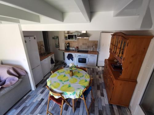 une cuisine avec une table et un chiffon de table jaune dans l'établissement Petite maison agréable à 300 m de la plage, à Dolus-d'Oléron