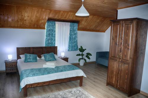 a bedroom with a large bed with blue pillows at Casa Camelia in Săcel