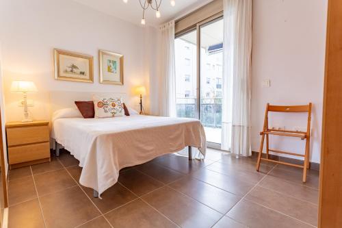a bedroom with a bed and a large window at MARITIM Family Muntanya Ambar in Salou
