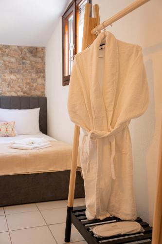 a robe hanging on a clothes rack in a bedroom at Kyklon Maisonette in Afitos