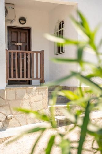 a building with a wooden door and a balcony at Kyklon Maisonette in Afitos