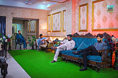 a group of men sitting on a couch in a living room at Quick continental Hotel - Jail Road in Lahore