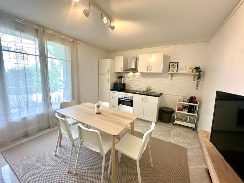 une cuisine avec une table et des chaises dans une pièce dans l'établissement Au Coeur du Quartier Taittinger, à Reims