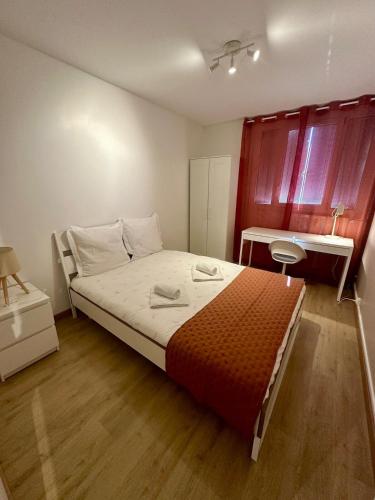 une chambre avec un grand lit et un bureau dans l'établissement Au Coeur du Quartier Taittinger, à Reims