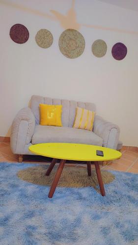 a living room with a couch and a yellow coffee table at Natna's 1 bedroom near Bofa Beach in Tezo