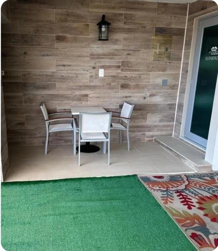 a dining room with a table and chairs and a green rug at Seven Seas Studio Los Roires Beach Apartments in Fajardo