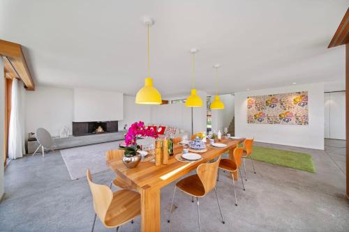 a dining room with a wooden table and chairs at Villa Serenity Sustainable Luxury Retreat by GuestLee in Preverenges