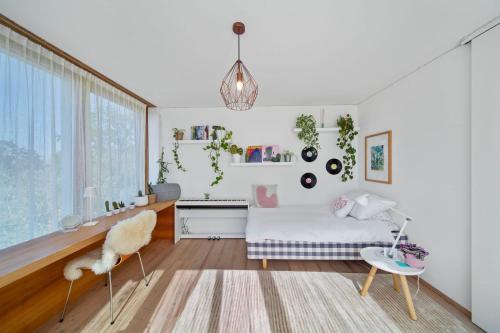 a bedroom with a bed and a desk and a chair at Villa Serenity Sustainable Luxury Retreat by GuestLee in Preverenges