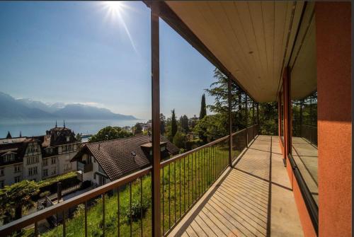 a balcony with a view of a city at Villa Rose in the center of Montreux by GuestLee in Montreux